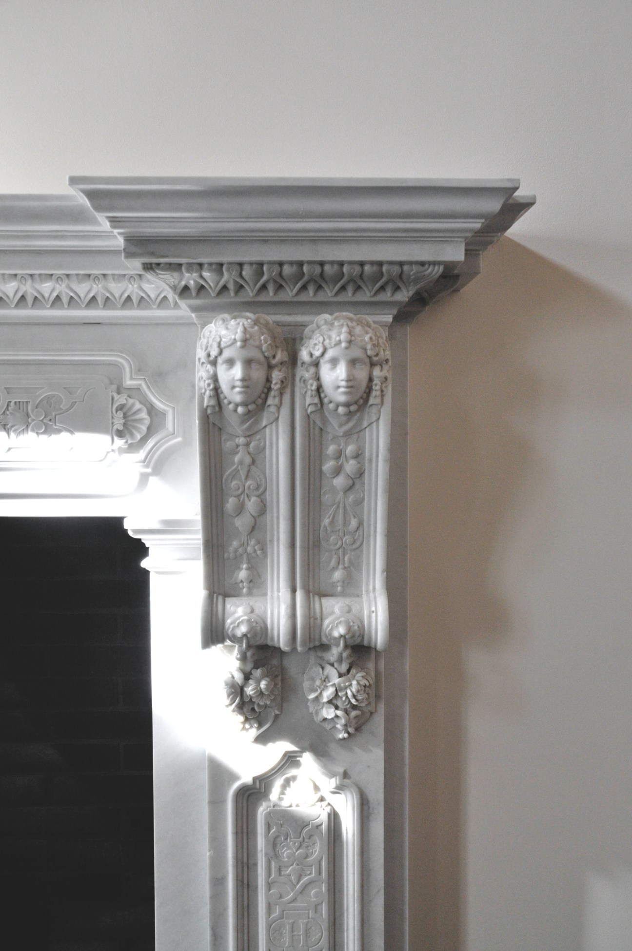 Ornate white fireplace detail with carved caryatid heads and decorative molding at the Dolder Grand hotel.