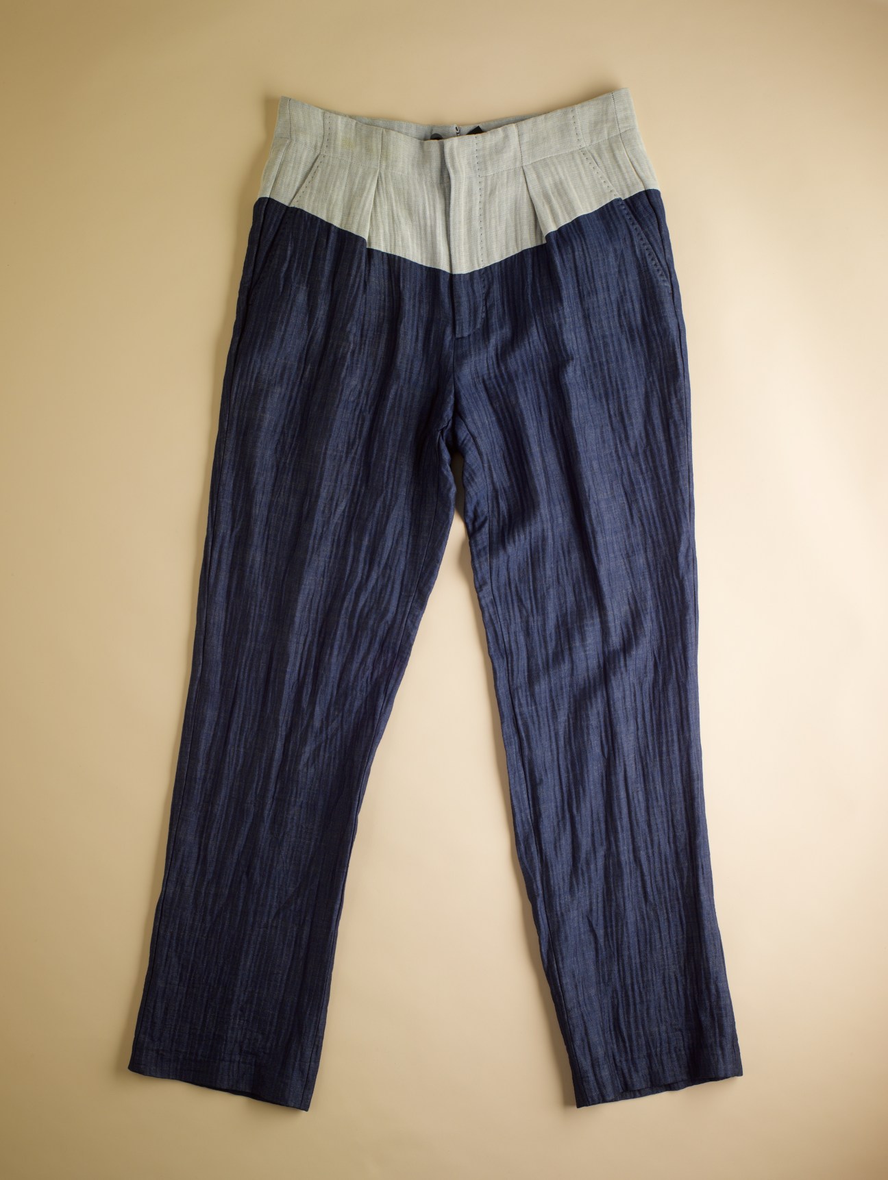 Navy and cream pinstriped suspender trousers with a high waistband against a neutral background.