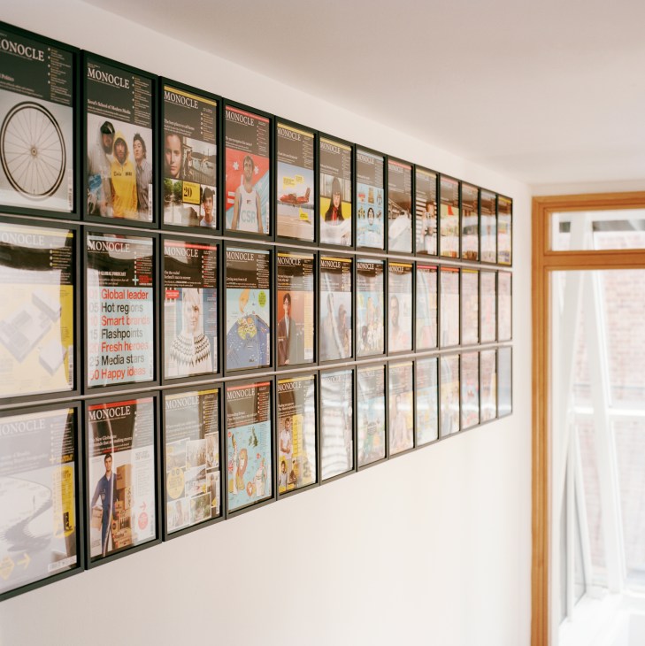 Wall display of framed Monocle magazine covers in black-framed grid arrangement.