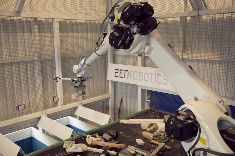 ZenRobotics intelligent recycling robot with black gripper arm sorting construction waste materials.