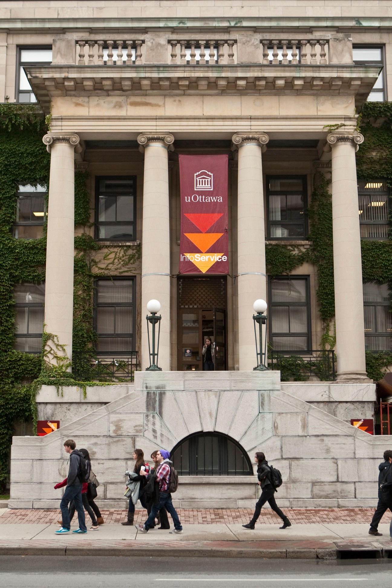 University of Ottawa neoclassical building with ivy-covered facade and students walking outside.