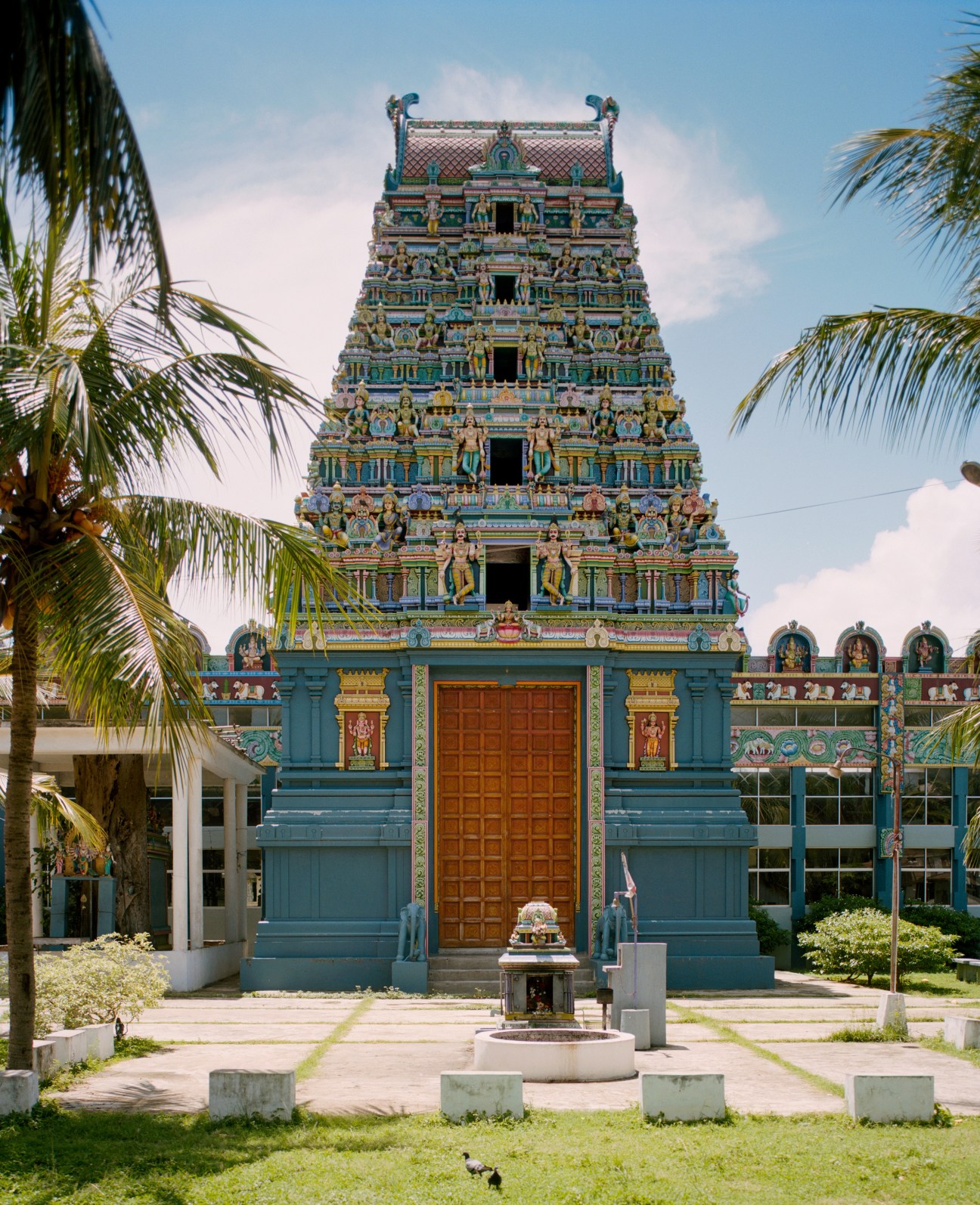 Colorful Hindu temple with ornate tiered tower and blue facade in Colombo