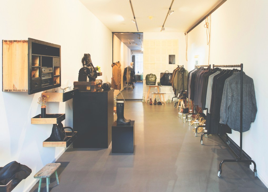 Interior of Oukan 71 concept store in Berlin displaying Japanese fashion and products with wooden display fixtures and clothing racks.