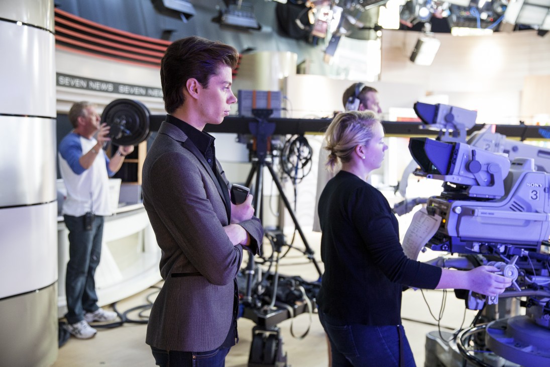 Michael Pell, executive producer of Sunrise, stands in the Channel Seven studio with camera equipment and crew visible in the background.