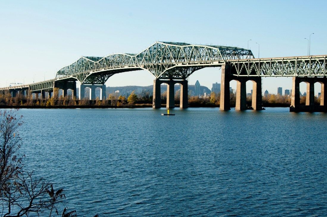 The aging Pont Champlain steel bridge spanning the St. Lawrence River with Montreal skyline visible in background.