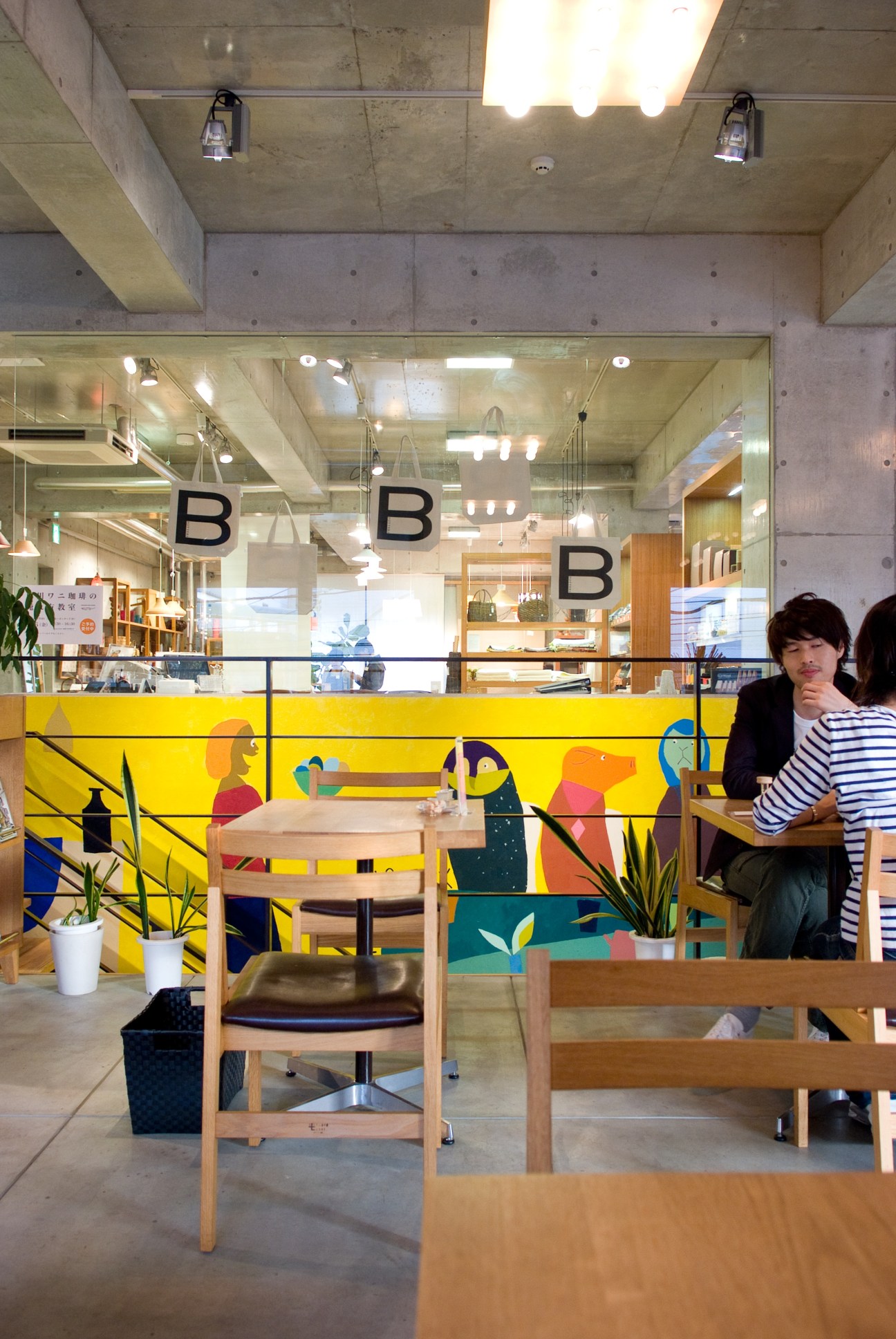 Interior of B.B.B. potters café with wooden furniture and colorful mural artwork.