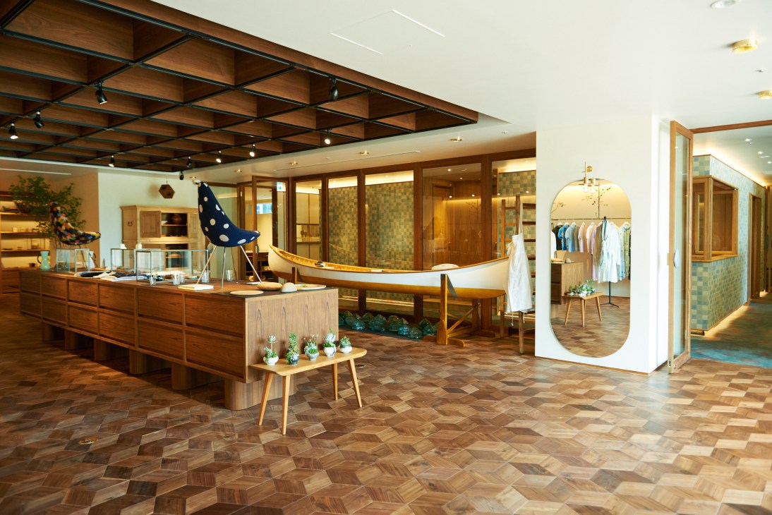 Call shop interior in Tokyo featuring wooden fixtures, mid-century furniture, and display areas for Minä Perhonen clothing and textiles.