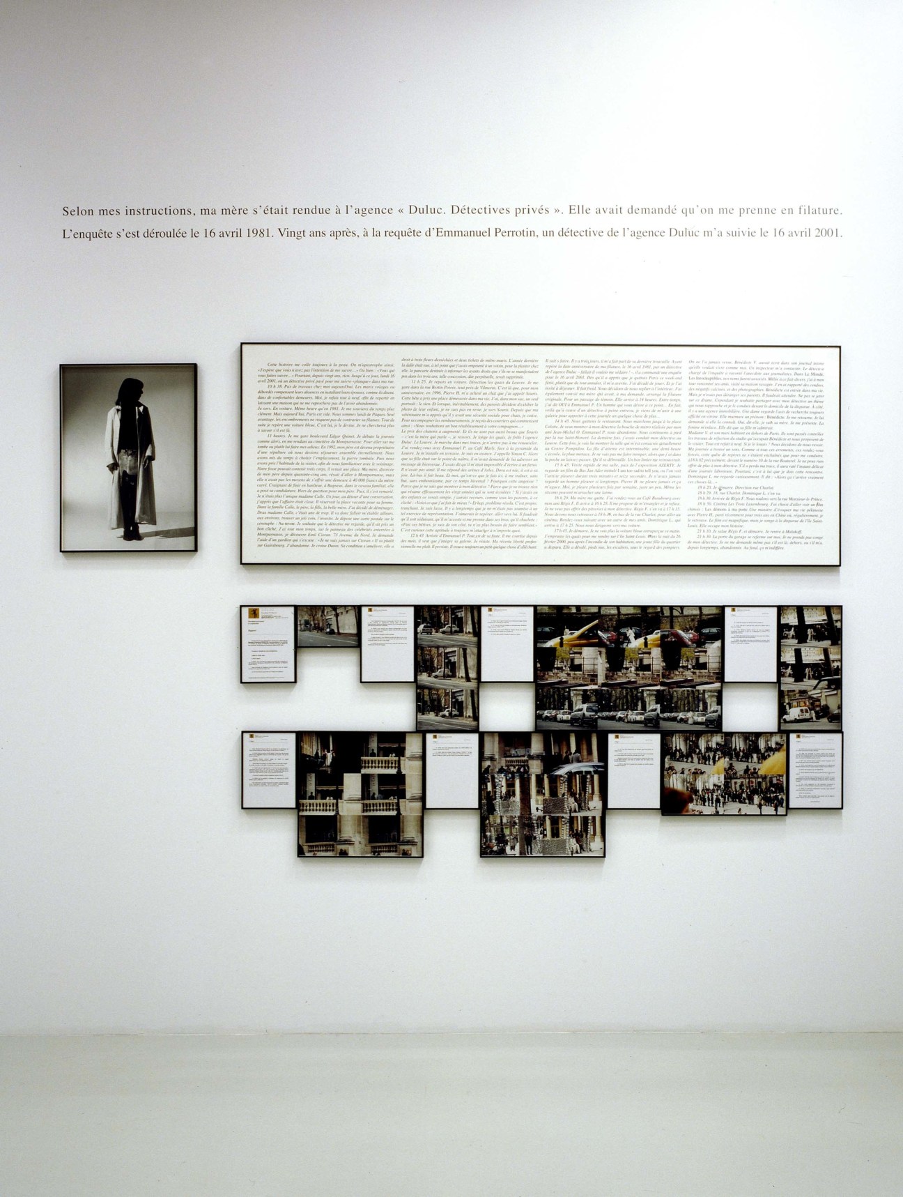 Gallery wall installation with framed photographs and text panels arranged in an asymmetrical layout by Sophie Calle.