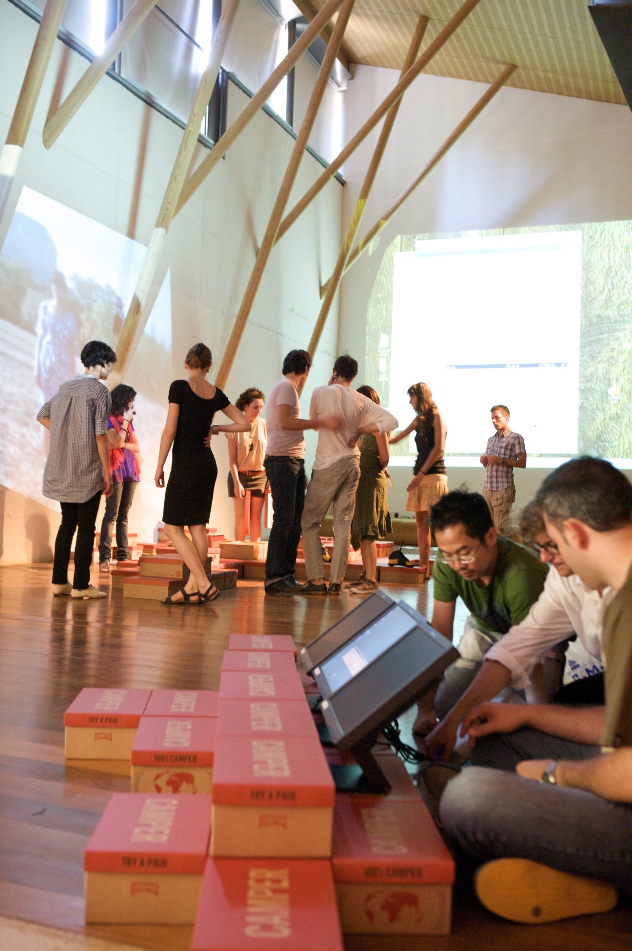 Students prepare a presentation in a modern auditorium with wooden beams and large windows at Son Forteza.