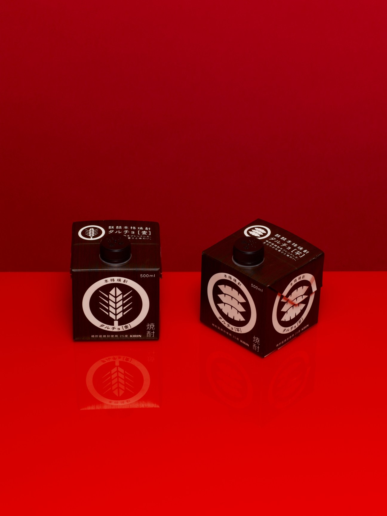 Two dark brown Tarucho shochu cartons with white kamon illustrations on a red background.