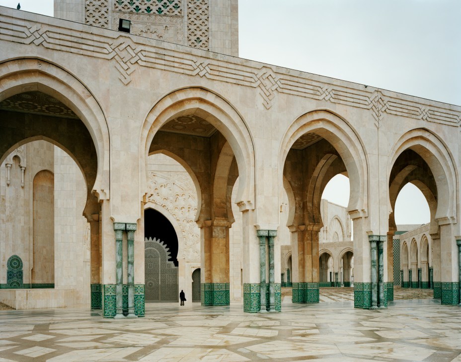 The Hassan II Mosque's courtyard with arched columns, green tilework, and geometric patterns in Casablanca.