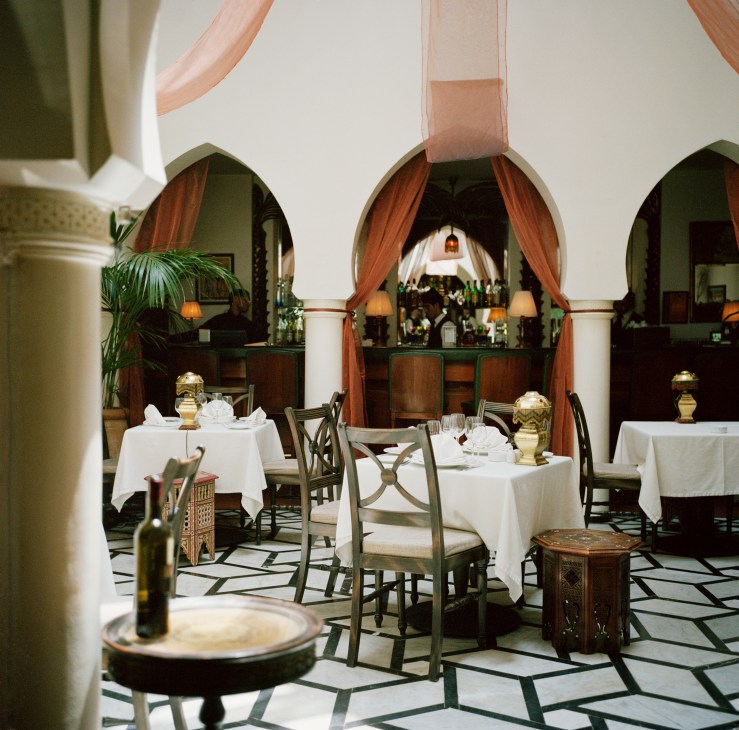 Rick's Cafe dining room with arched doorways, white tablecloths, and ornate Moroccan design elements.