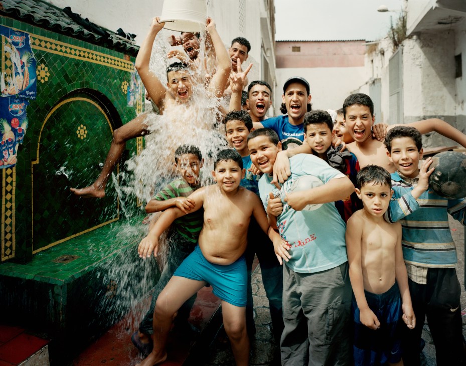 Children playing joyfully with water splashing in the Old Medina of Casablanca.