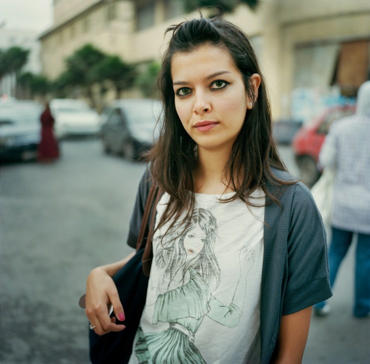 Somaya, a 24-year-old student, stands on Avenue Mers Sultan wearing a graphic t-shirt and cardigan.