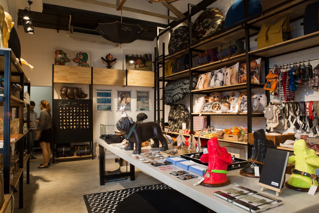 Interior of Fetch Shop showing shelves stocked with dog products, artwork, and a black dog statue on display counter.