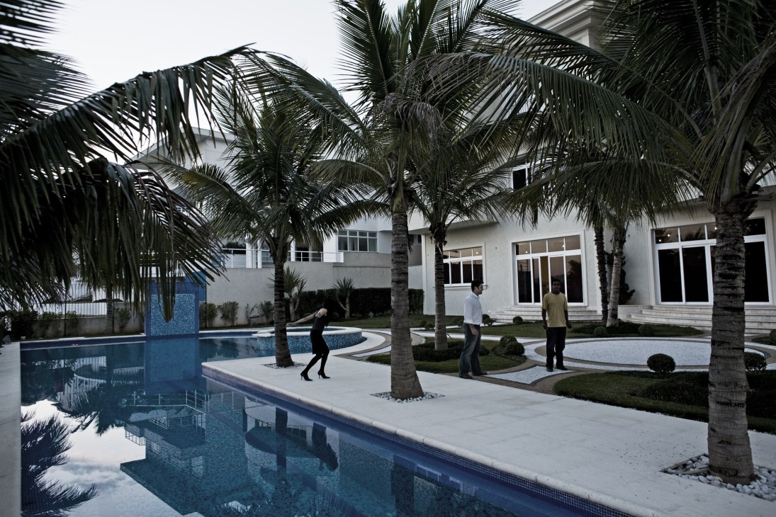 Estate agents showing prospective buyers a luxurious home with swimming pool and palm trees in AlphaVille.