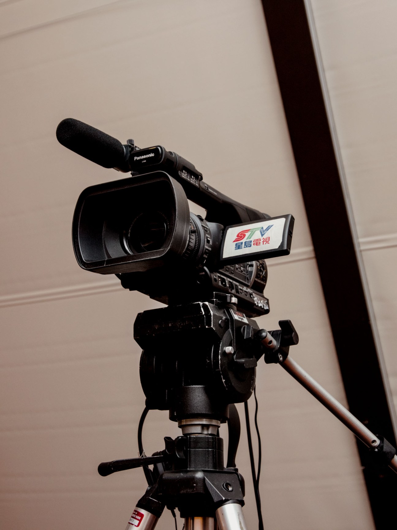 Professional video camera on tripod with microphone, representing media coverage of San Francisco mayoral election.