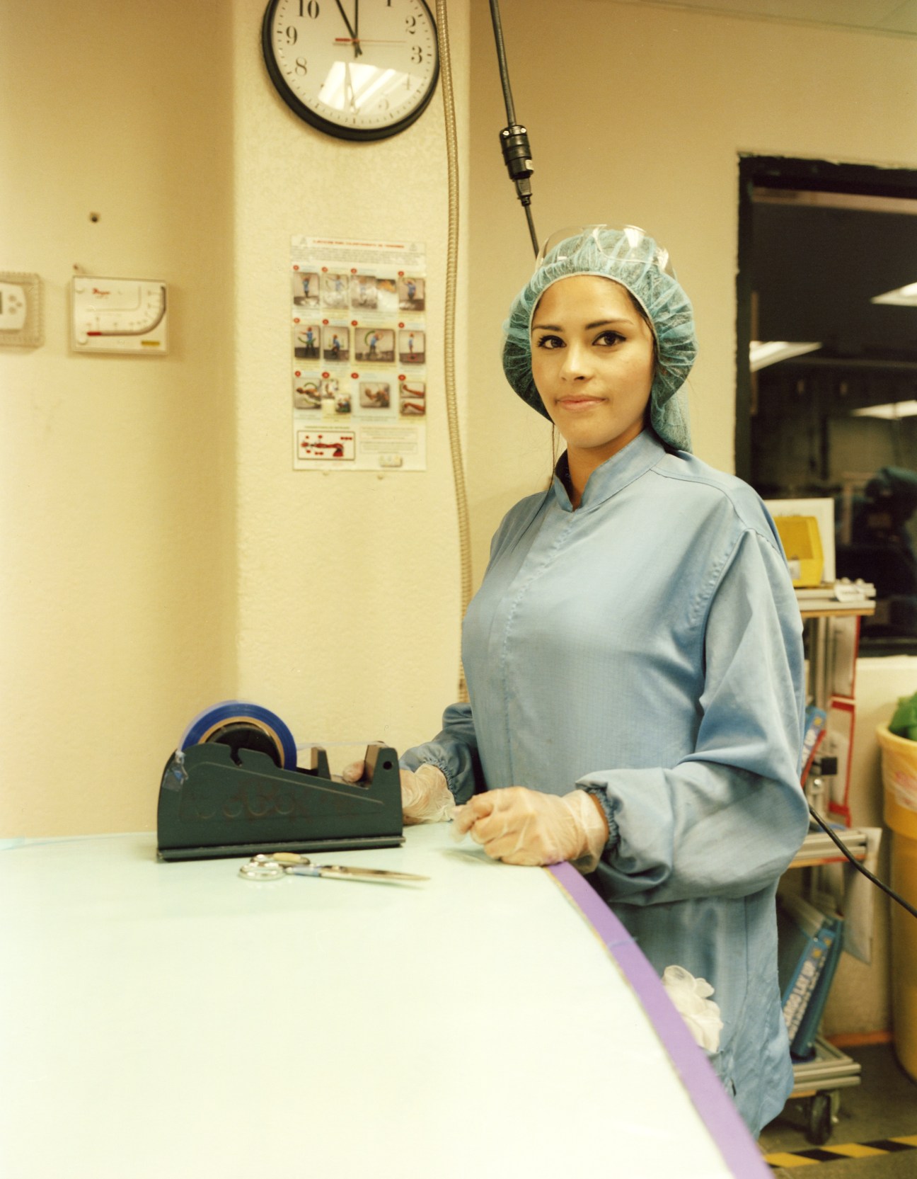 Worker at aircraft interior manufacturer Zodiac in blue uniform and hairnet at workstation.