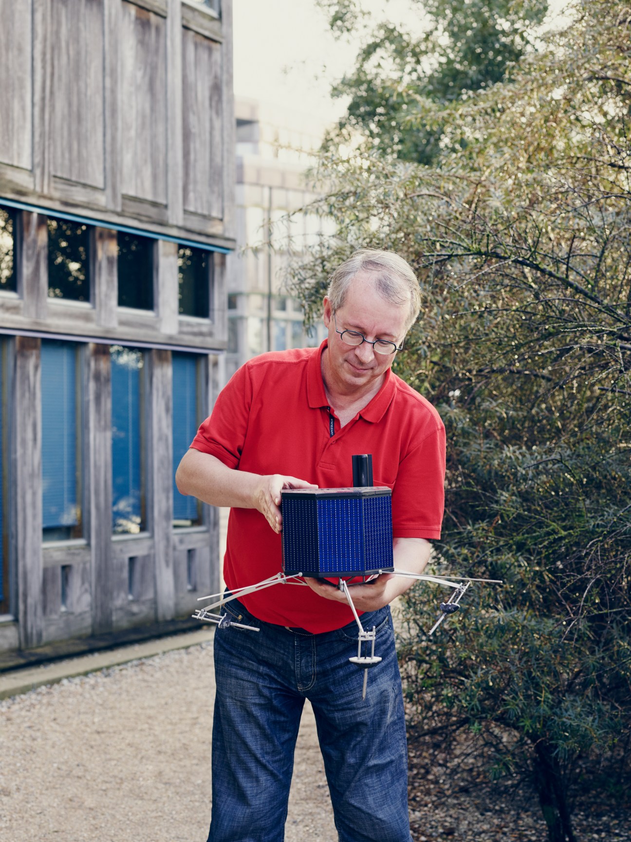 Fred Jansen, Rosetta mission manager, holds a model of the Philae probe outside an ESA building.