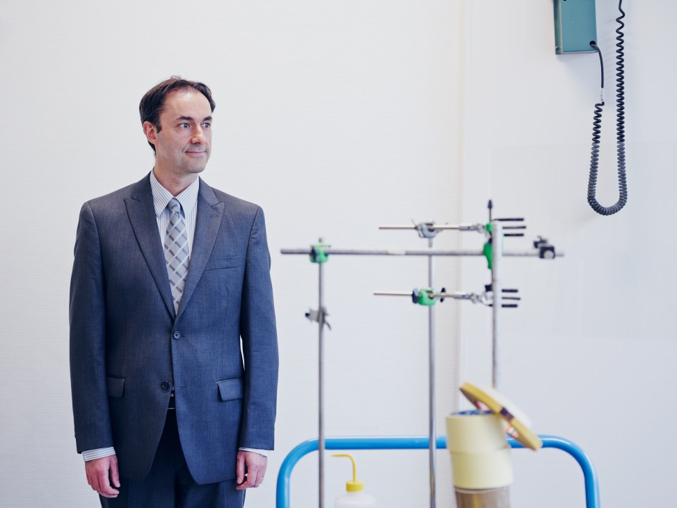 Ali Zadeh, head of components evaluation, stands in ESA's radiation test facility with testing equipment behind him.