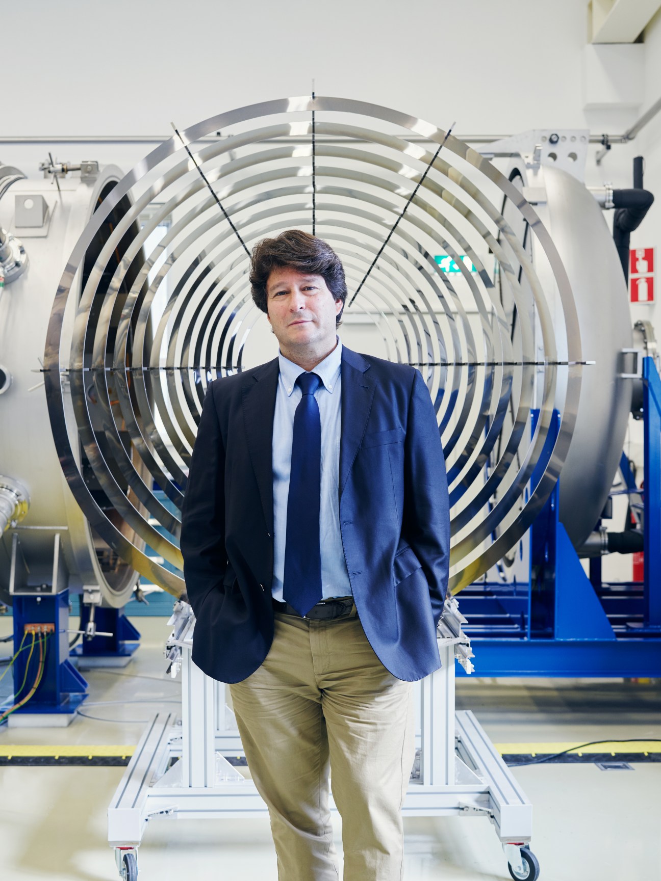 Jose Gonzalez del Amo stands in front of a large circular thruster chamber at ESA's Estec facility.