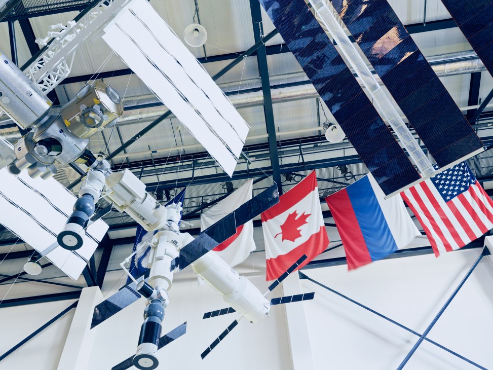 Model of the International Space Station with solar panels and flags of Canada, France, and the United States.