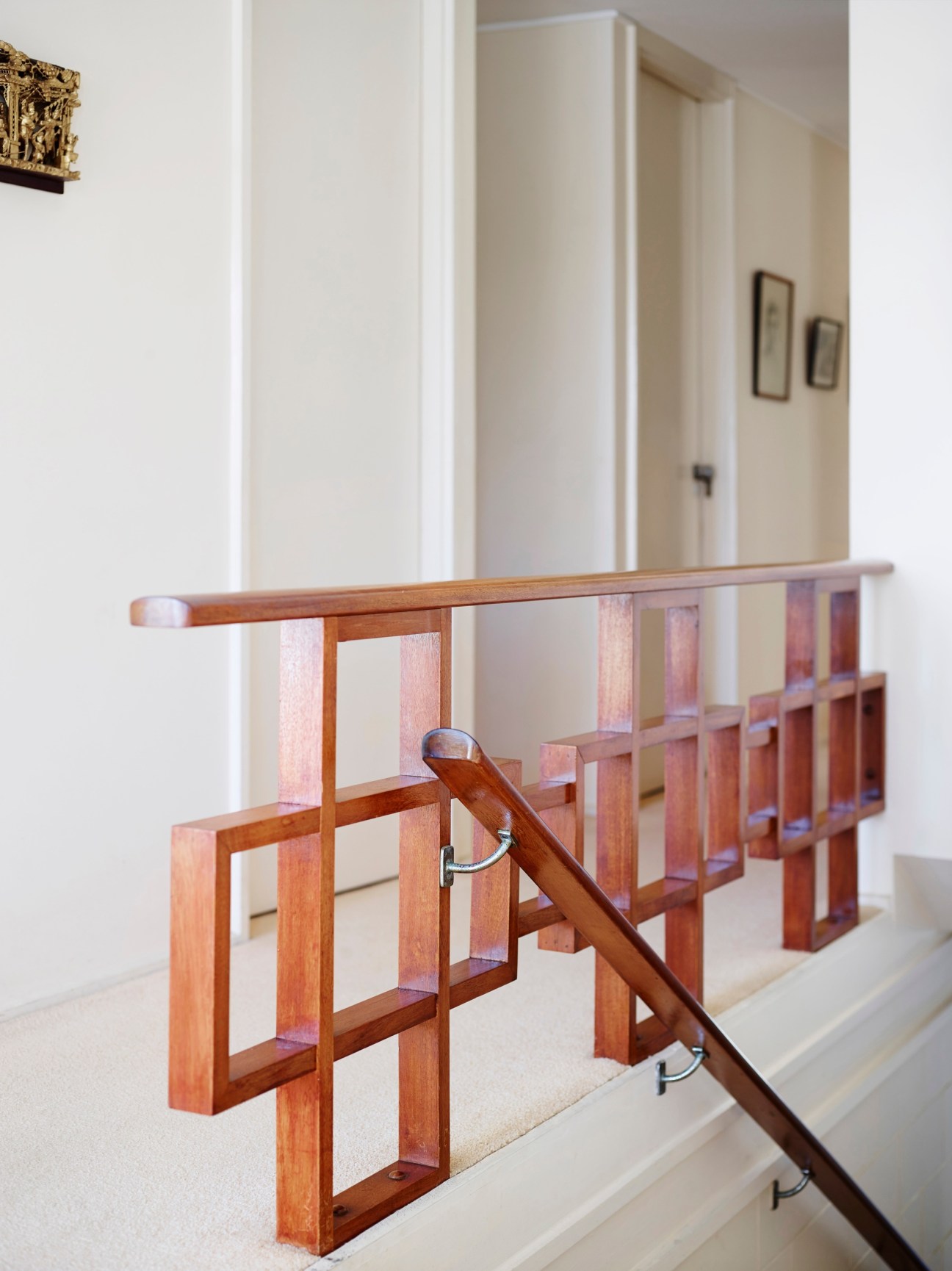 Rich-maple geometric banister and hallway in a mid-century Gold Coast residence.