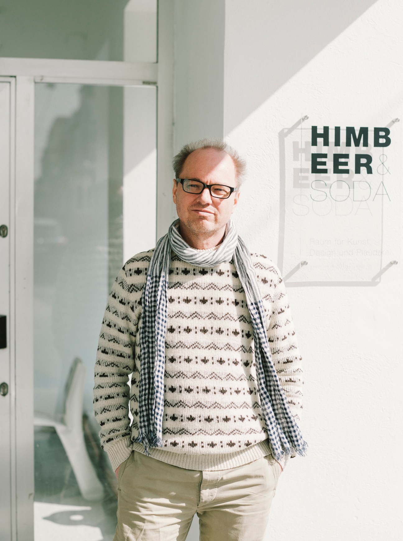 Michael Turkiewicz, co-owner of Himbeer & Soda design gallery in Vienna, standing in a bright white interior space.