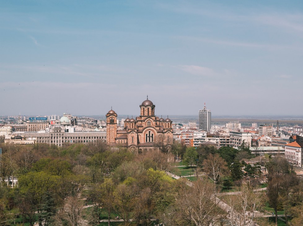 View across Tasmajdan Park to St Mark's Church with its distinctive copper domes and Belgrade cityscape beyond.