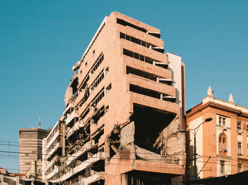 Damaged government building in Belgrade with broken windows and structural damage from 1999 NATO air strikes.