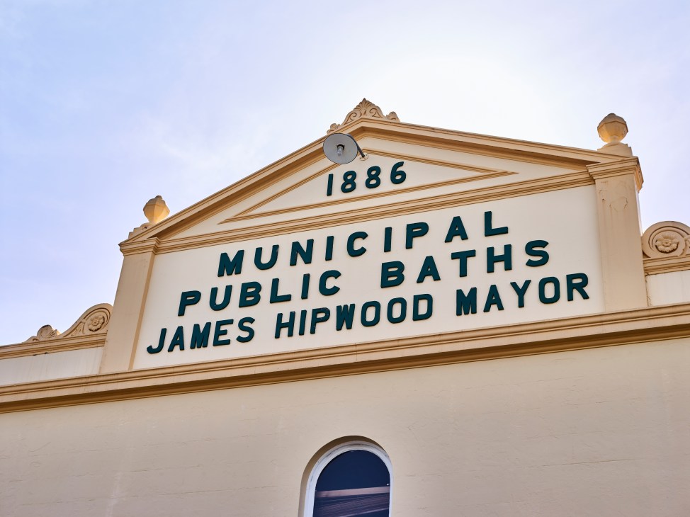 Historic facade of Municipal Public Baths with 1886 date and James Hipwood Mayor inscription.