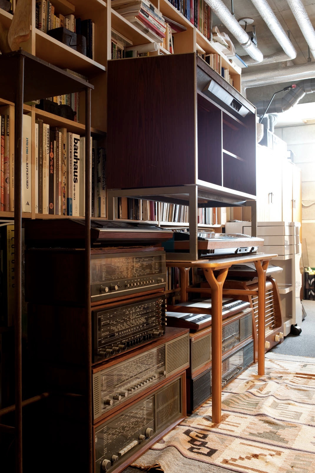 Bang & Olufsen audio system with vintage components displayed in wooden shelving unit in study.
