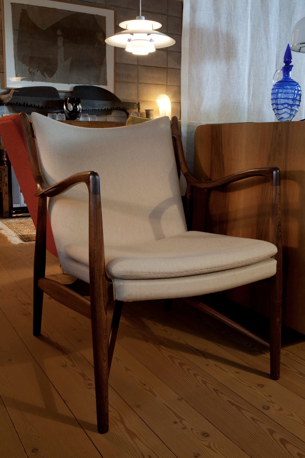 Easy Chair no 45 by Finn Juhl with cream upholstery and wooden frame in a modern interior.
