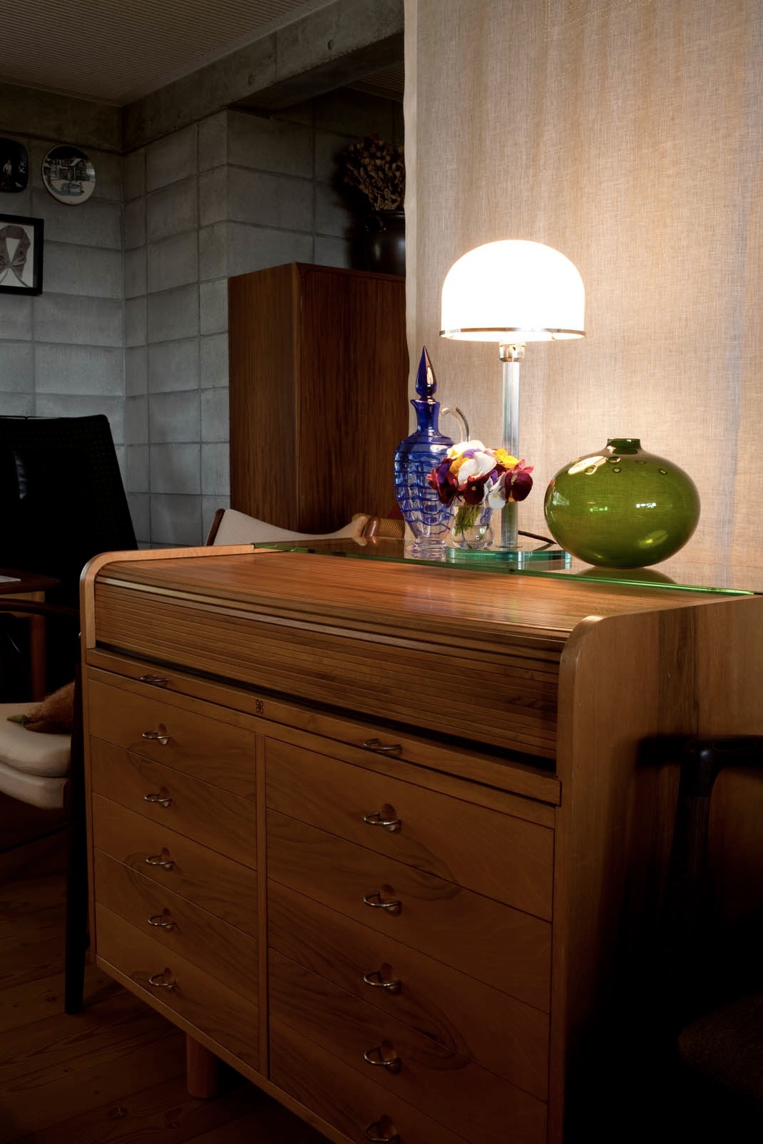 Wooden desk by Gianfranco Frattini with a modern dome lamp, flowers, and decorative objects.