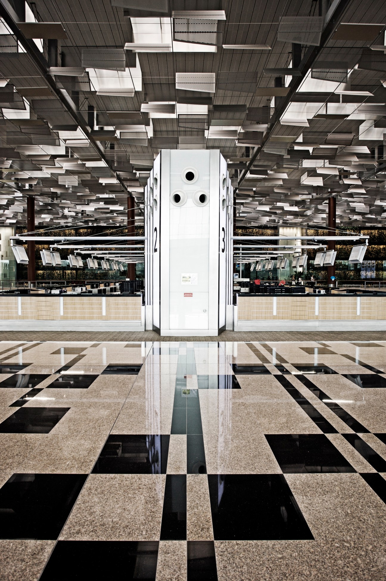 Changi Terminal 3 departure hall with geometric floor pattern, white zonal beacon tower, and louvred ceiling skylights.