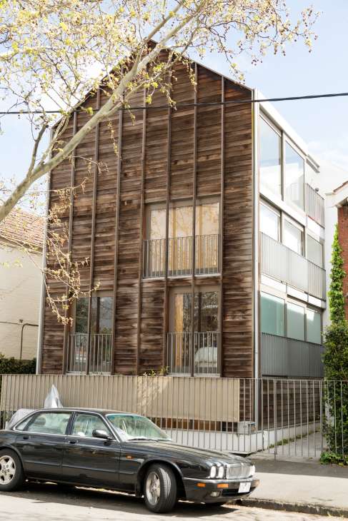 Modern wooden-clad apartment building with large windows on a Melbourne street.
