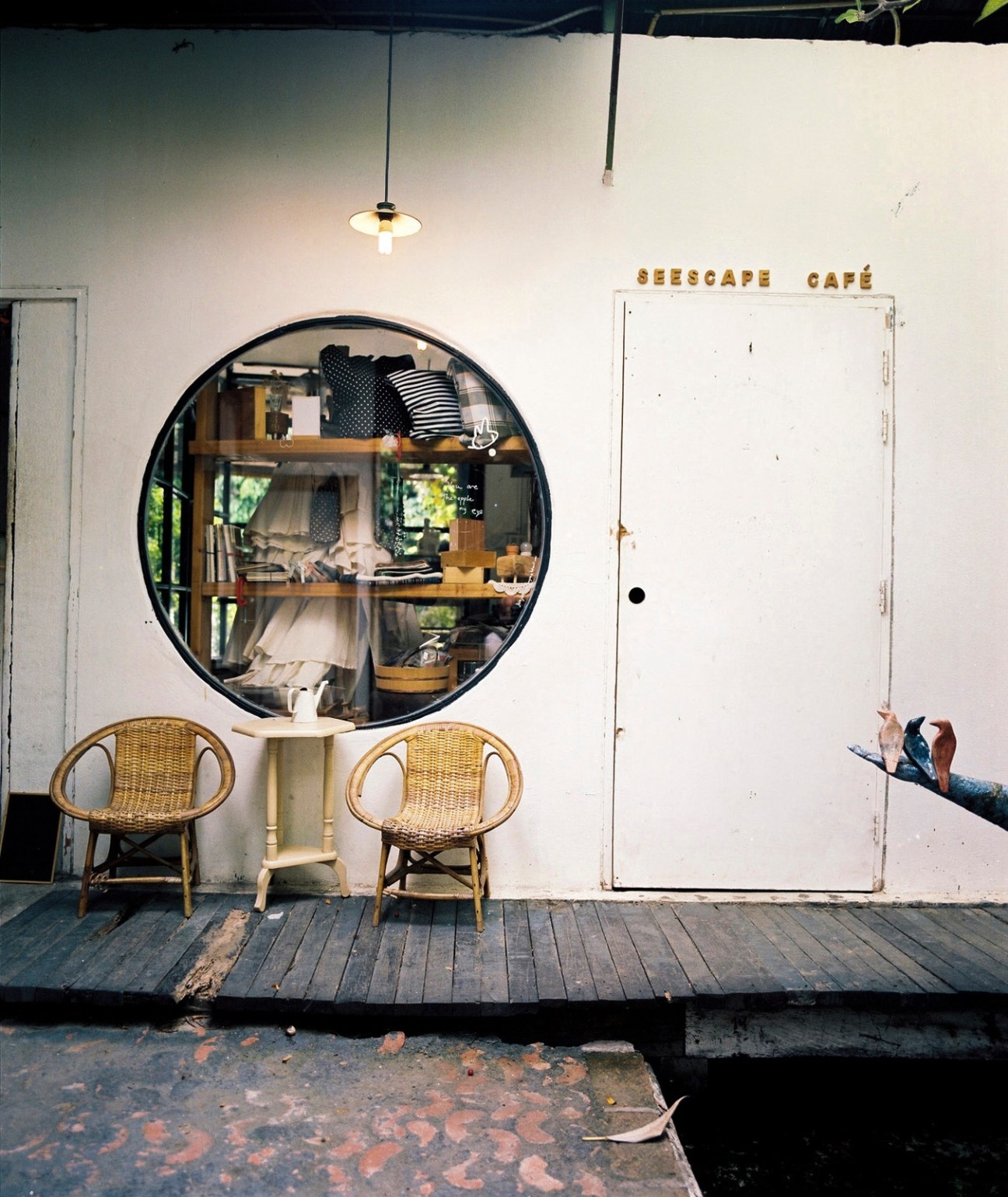SeeScape café storefront with rattan chairs and a circular black-framed window display.
