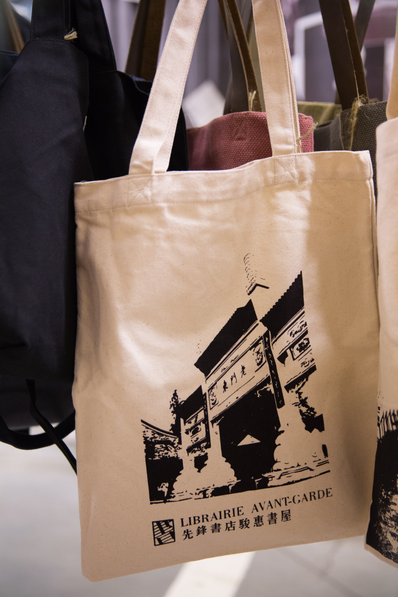 Canvas tote bags branded with Librairie Avant-Garde logo and Chinese characters.