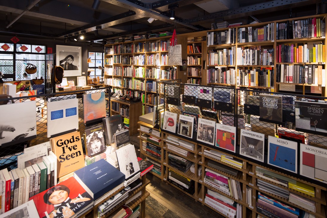 Interior of The Mix Place bookshop in Shanghai with wooden shelves, displayed art books, and merchandise.