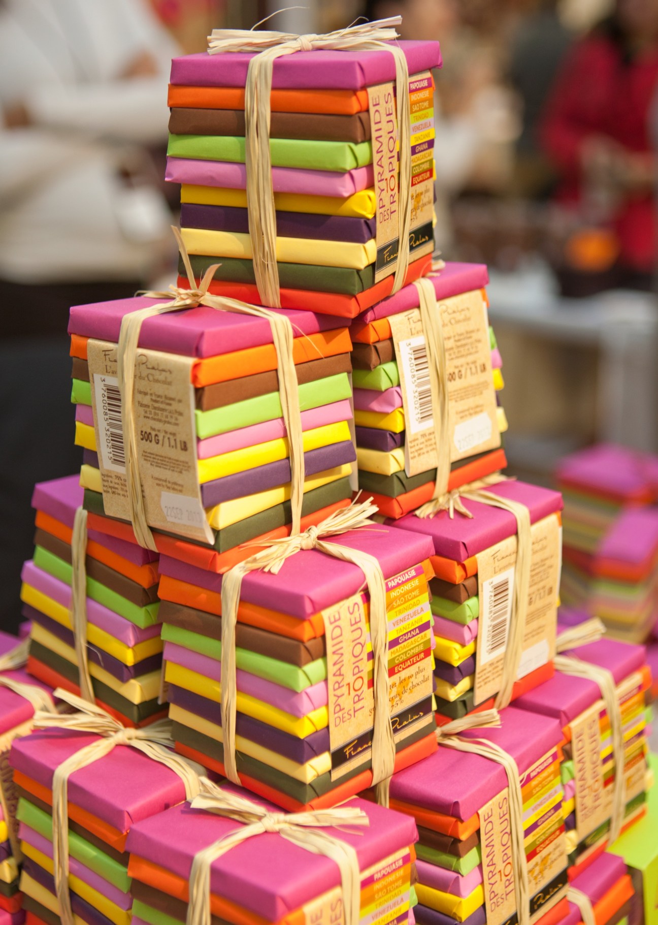 Colorful stacked Pyramide des Tropiques chocolate bars from Pralus tied with twine bows.