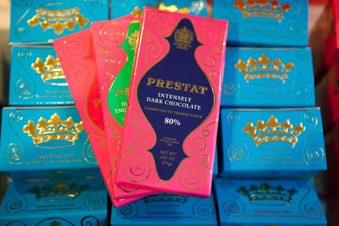 Prestat intensely dark chocolate 80% bar in pink packaging surrounded by blue boxes
