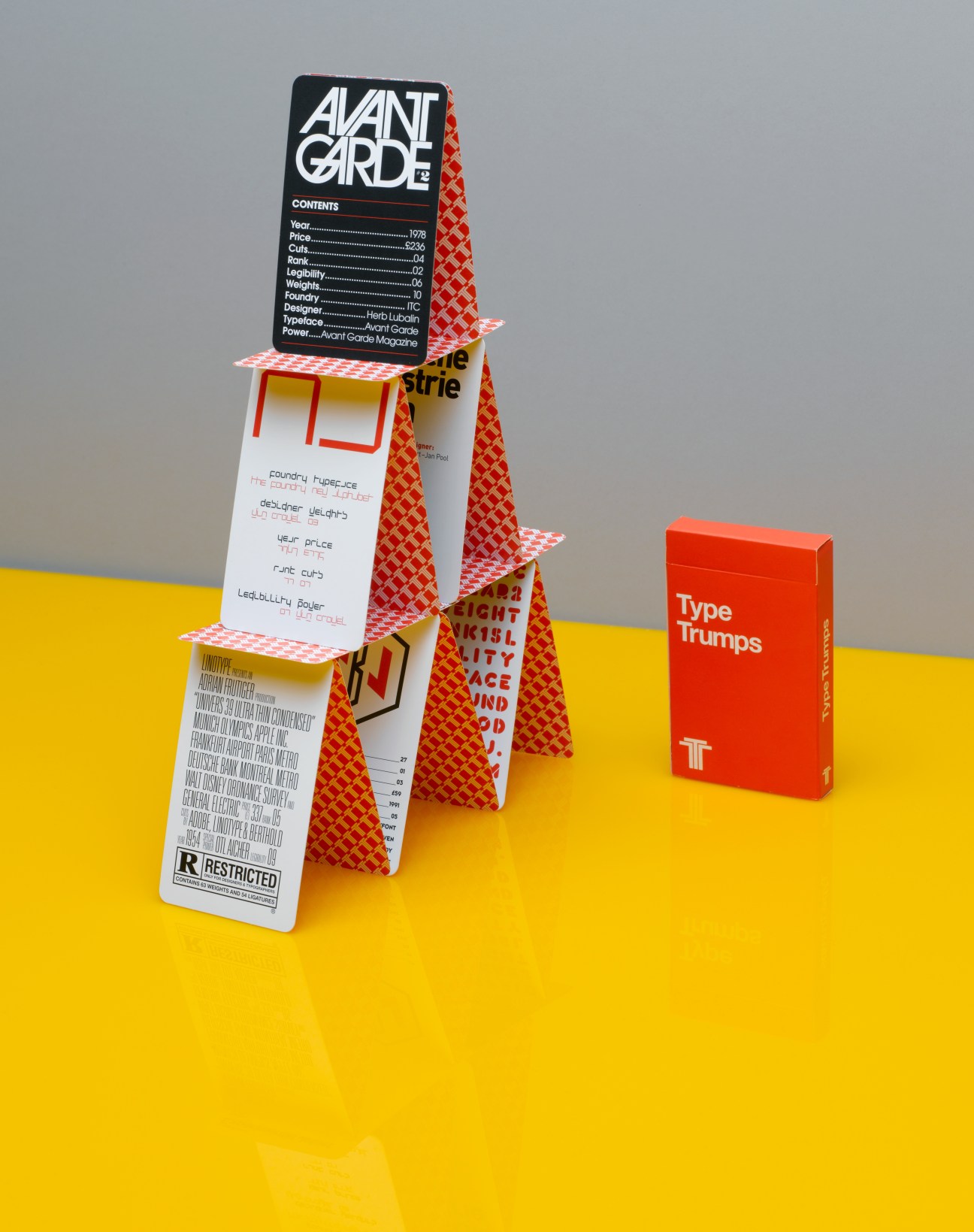 Type Trumps card game box displayed with stacked game cards featuring red patterned designs on yellow surface.