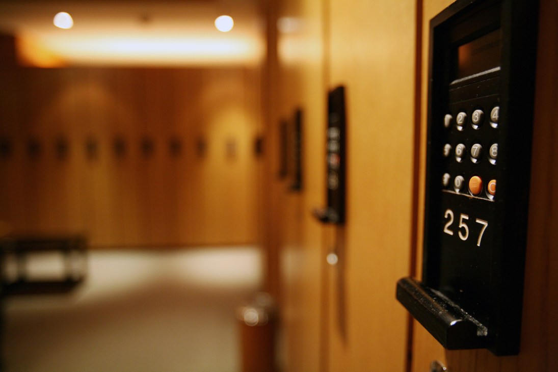 Hotel elevator interior with illuminated floor buttons and warm golden lighting.