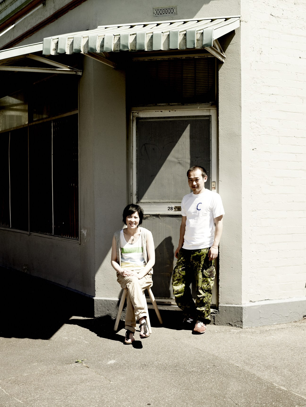 Meg and Zenta Tanaka standing outside their converted milk bar home in Collingwood.