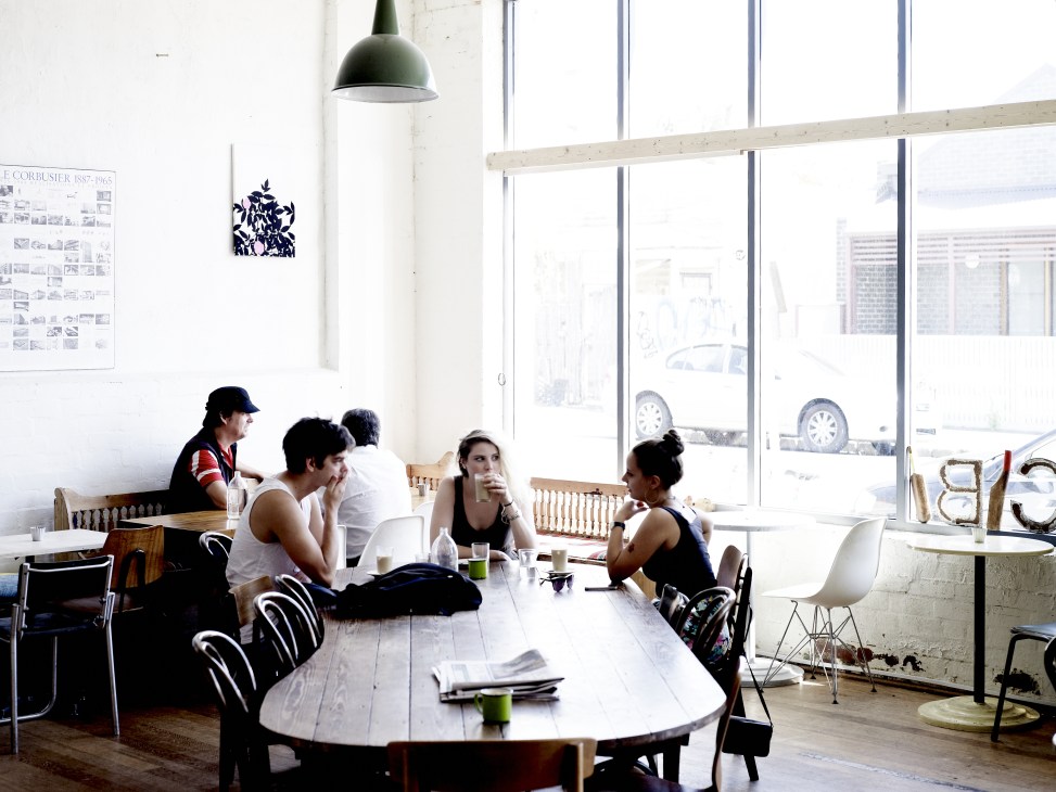 Interior of Cibi café with customers seated at tables by large windows in a bright, minimalist space.