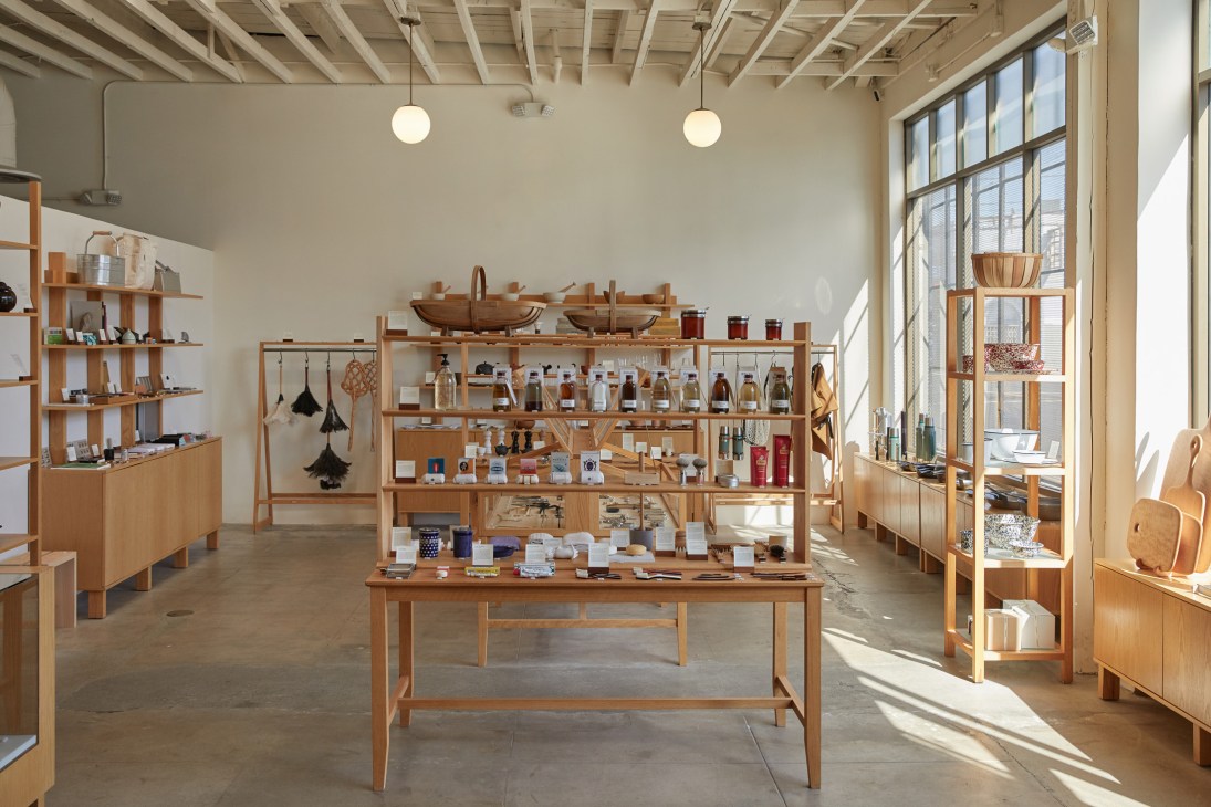 The Good Liver store interior in Los Angeles showing wooden shelving, pendant lights, and displayed merchandise