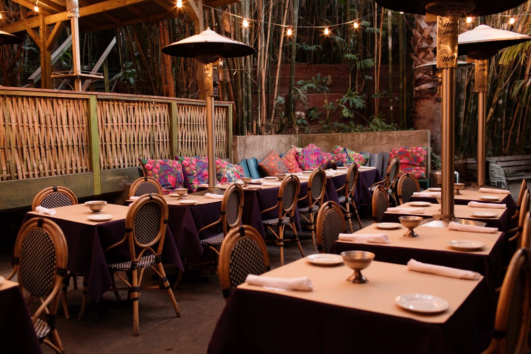 Cliff's Edge restaurant patio with rattan chairs, colorful cushions, and bistro-style dining setup under string lights.