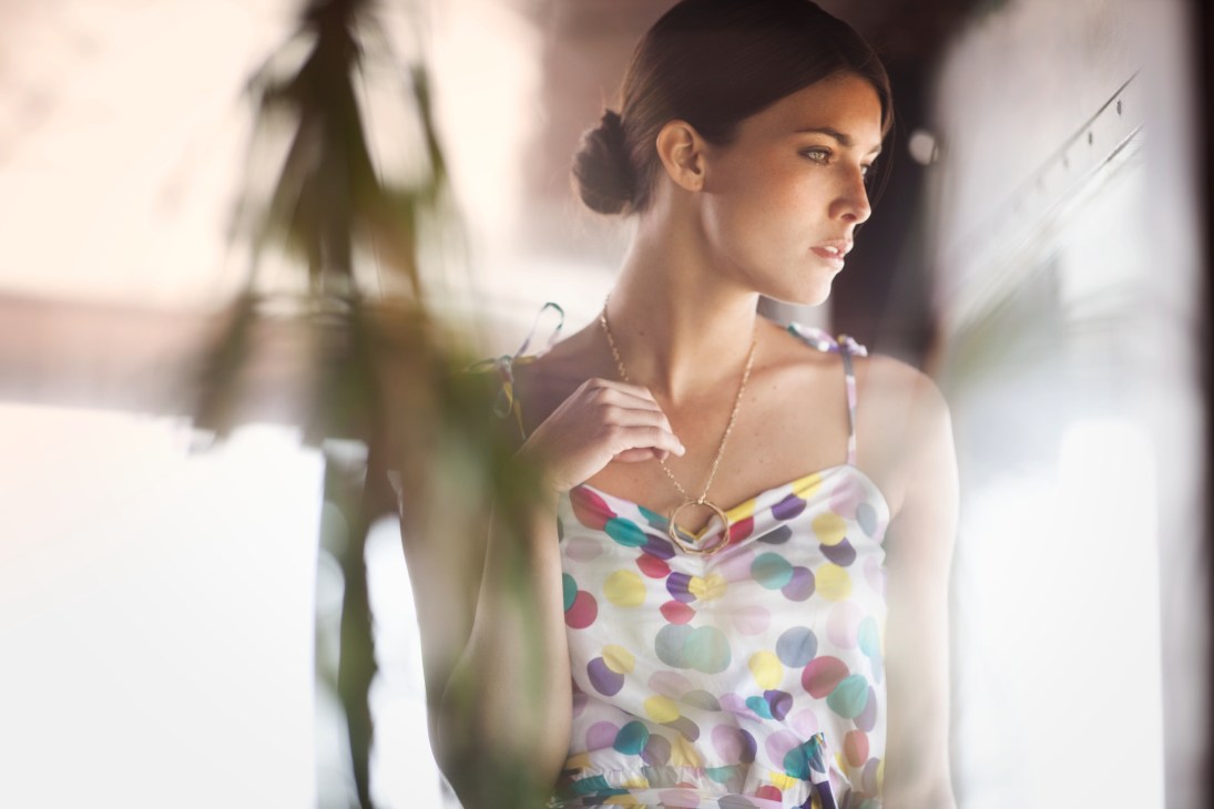 Woman wearing a colorful polka dot dress by Kitsuné and A.P.C. necklace in bright daylight.
