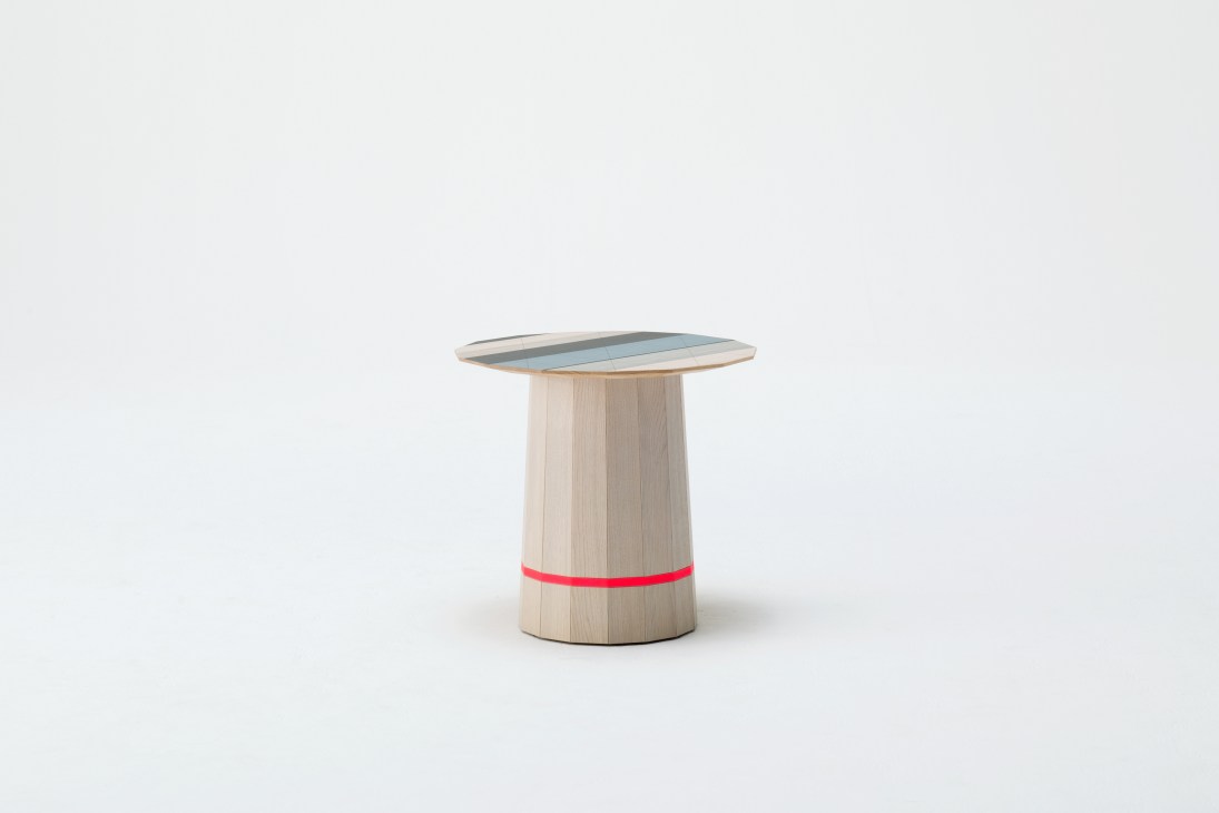 Wooden side table with light wood cylindrical base, red band detail, and teal-blue top surface.