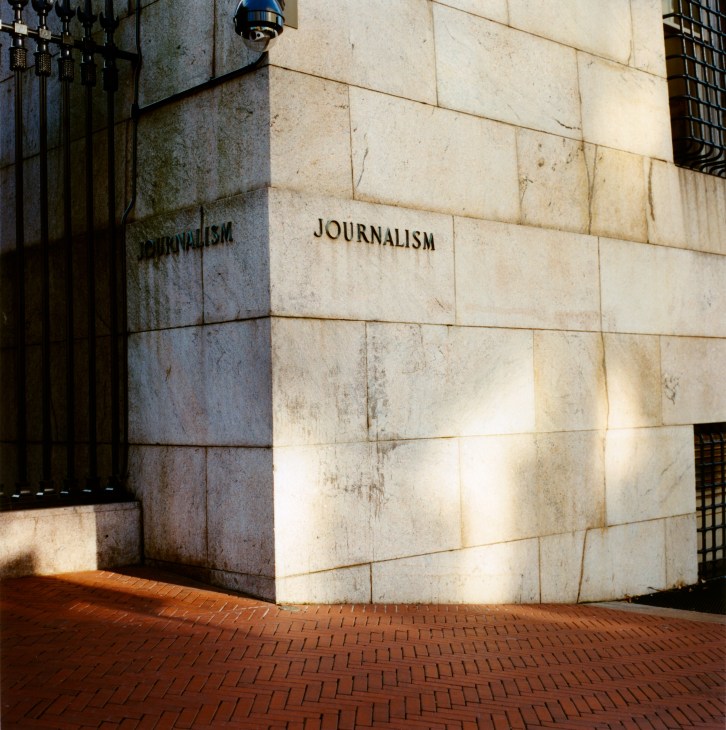 Stone exterior wall of Columbia University School of Journalism building with engraved lettering.